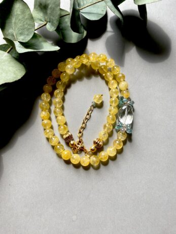 close up of a necklace with yellow beads