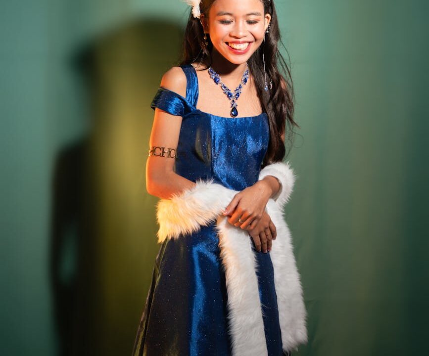 young woman in elegant blue dress smiling