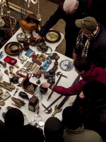 antique collectors browsing at flea market table