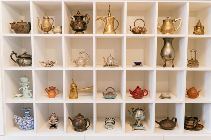 a variety of teapots in a shelf