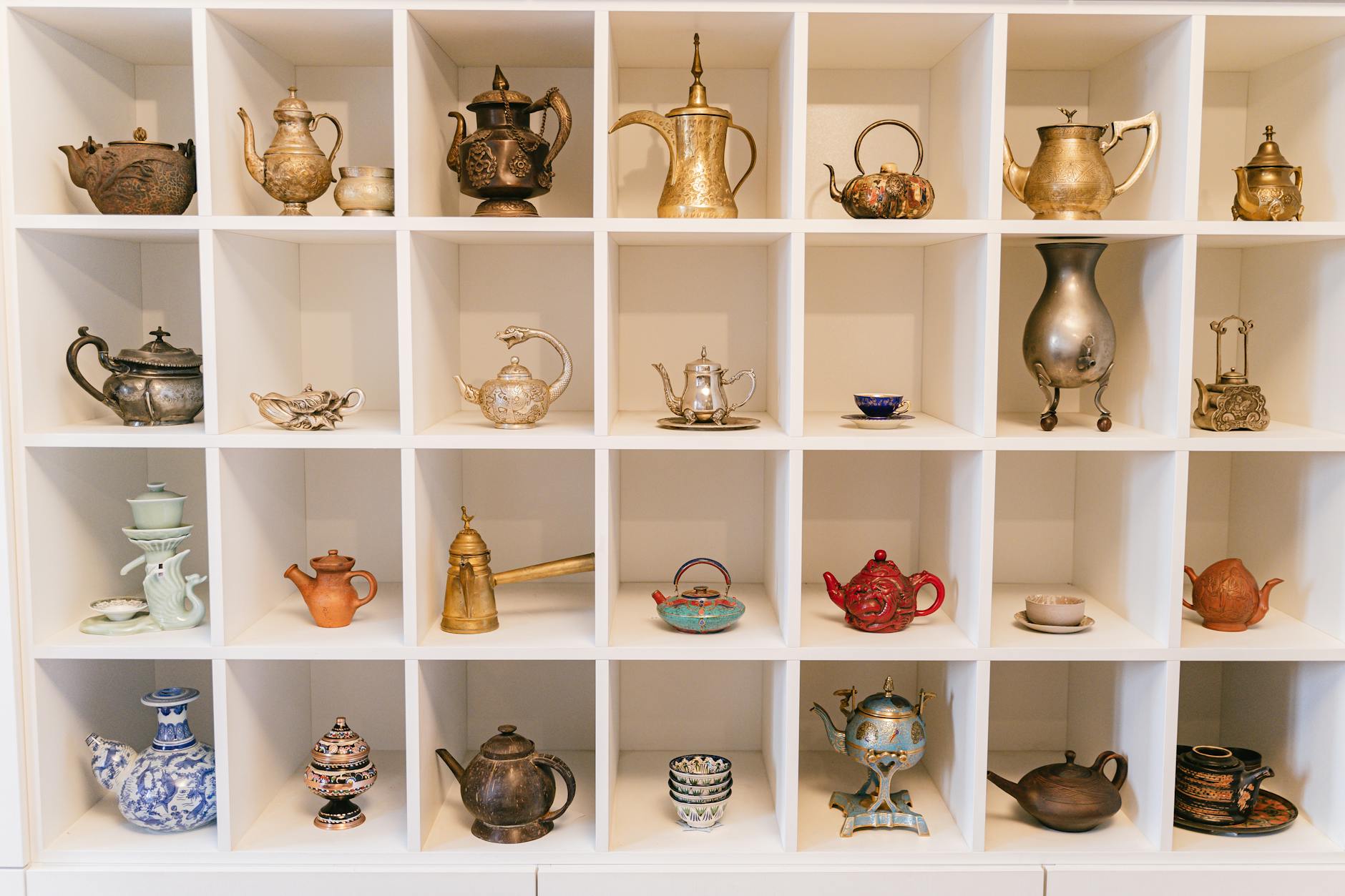 a variety of teapots in a shelf