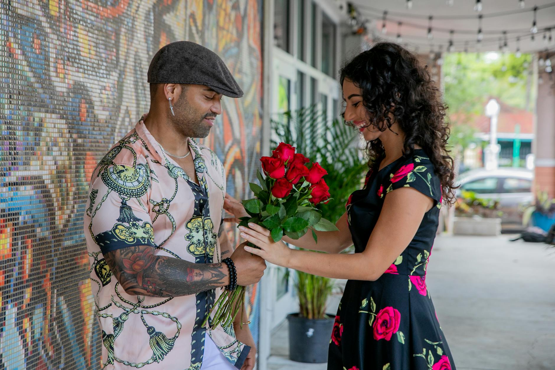 man giving red roses to the woman