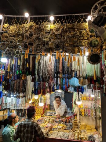 three men surrounded with jewelries during nighttime